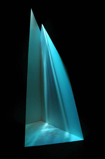 A projector in a corner projects a blue image down onto the walls and floor